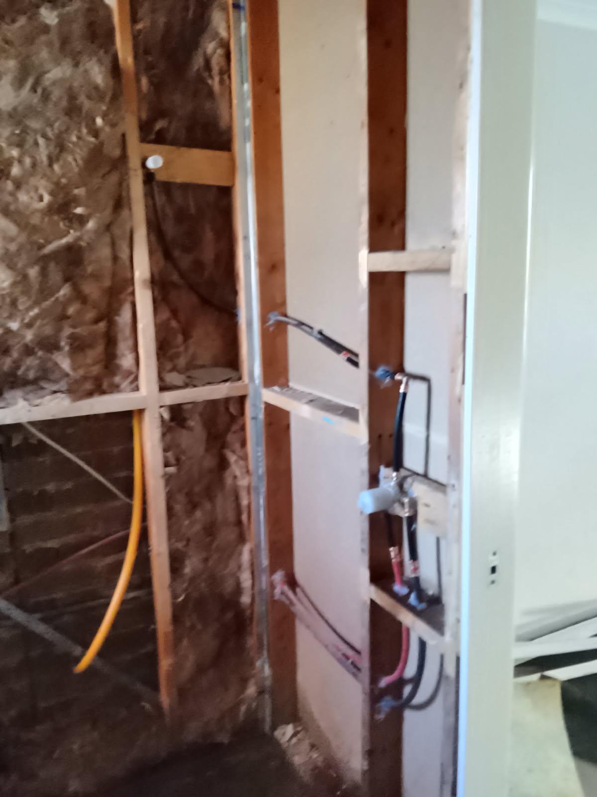 Hot and cold pex lines and gas line roughed into an open bathroom wall cavity